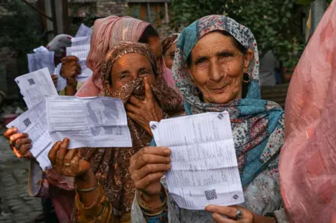 Getty Images Masyarakat mengantri untuk memberikan suara di tempat pemungutan suara selama fase kedua pemilihan umum di Srinagar, Kashmir yang dikelola India, pada 25 September 2024. 