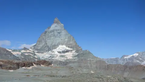 Getty Images Matterhorn melintasi perbatasan utama antara Italia dan Swiss. Letaknya di dekat puncak piramida besar simetris yang puncaknya 4.478 m. Pemandangan ini dari Zermatt