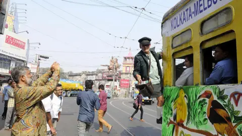 AFP Oberto D'Andrea, seorang kondektur trem di Melbourne, menikmati perjalanan dengan trem yang baru didekorasi untuk merayakan ulang tahun ke-20 (1996 - 2016) Kolkata Melbourne Tramjatra yang tiba di Esplanade pada 10 Desember 2016 di Kolkata, Kolkata pada bulan Desember 10, 2016.