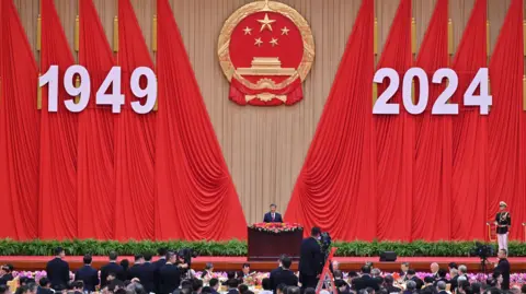 Getty Images Presiden Tiongkok Xi Jinping berpidato di resepsi Hari Nasional yang menandai peringatan 75 tahun Republik Rakyat Tiongkok.