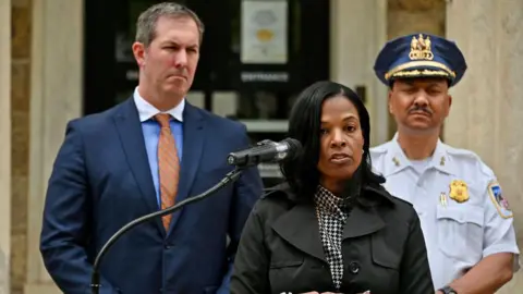 Getty Images Dr. Miriam Rogers (tengah), Pengawas Sekolah Umum Baltimore County, dan Kepala Polisi Robert McCullough (kanan) berbicara pada konferensi pers