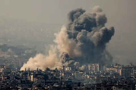 Reuters Asap mengepul di Dahih, pinggiran selatan Beirut, setelah serangan udara Israel pada Sabtu malam.