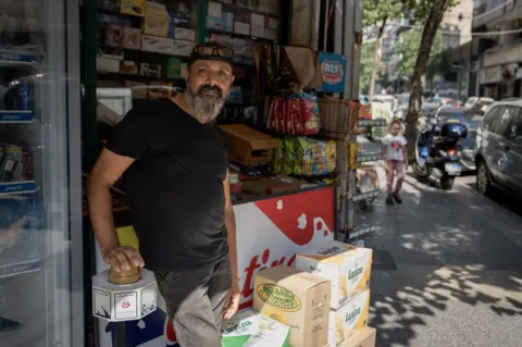 Joel Gunter/BBC Fadi Ali Kiryani di luar tokonya di Beirut. 