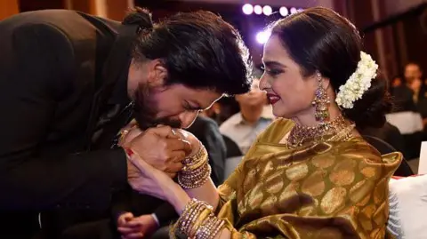 Getty Images Superstar Bollywood Shah Rukh Khan memberi selamat kepada Rekha pada upacara penghargaan