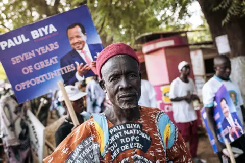 Getty Images Para pendukung Presiden Paul Biya berfoto setelah rapat umum pemilihan presiden Kamerun pada 29 September 2018, di Marua, Wilayah Utara Jauh Kamerun.