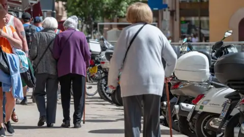 Getty Images Wanita lanjut usia berjalan dengan tongkat di Mallorca