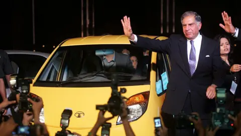 Getty Images Ketua Tata Sons - Ratan Tata berpose dengan Tata Nano saat peluncurannya di Mumbai pada hari Senin.