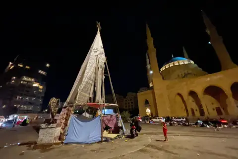 Orang-orang yang meninggalkan rumah mereka ada dimana-mana di Beirut – bahkan di bawah kerangka pohon Natal di Martyrs Square