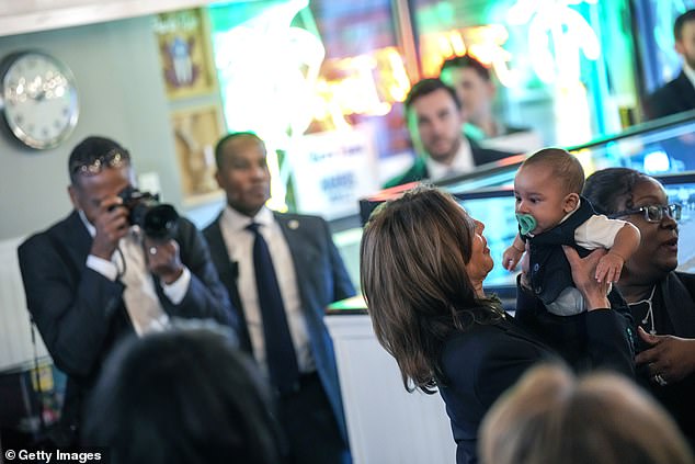 Kamala Harris memeluk bayi di Freddy & Tony's Restaurant, sebuah restoran Puerto Rico milik lokal di Philadelphia