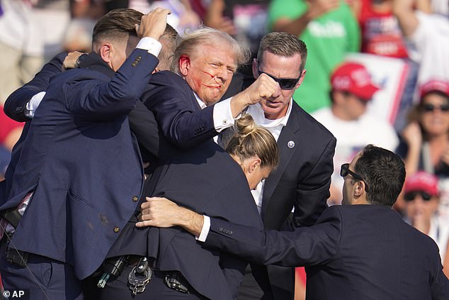 Mantan kandidat presiden dari Partai Republik Donald Trump dibantu turun dari panggung pada acara kampanye di Butler, Pennsylvania,