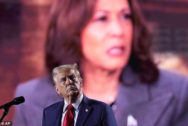 Trump menonton video yang menampilkan calon presiden dari Partai Demokrat Kamala Harris diputar selama acara kampanye pada hari Jumat di Detroit