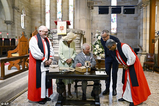 Raja Charles menandatangani salinan Alkitab saat Ratu Camilla melihatnya saat berkunjung ke Gereja Anglikan St Thomas