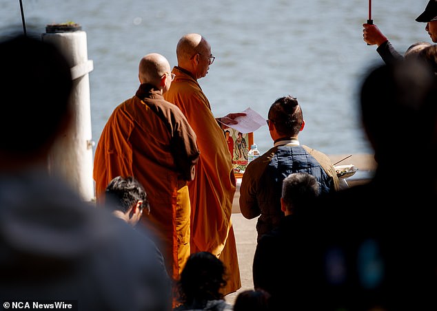 Para biksu Buddha memimpin doa dan membakar dupa saat komunitas lokal Vietnam berkumpul mendukung ayah tersebut