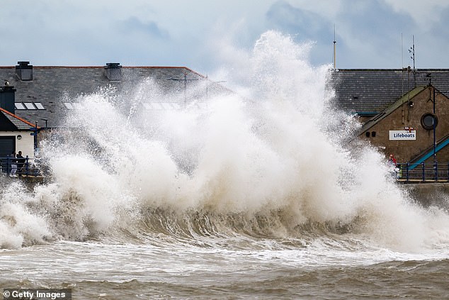 Ombak menerjang tembok pelabuhan Porthcawl di South Wales saat Badai Ashley kemarin