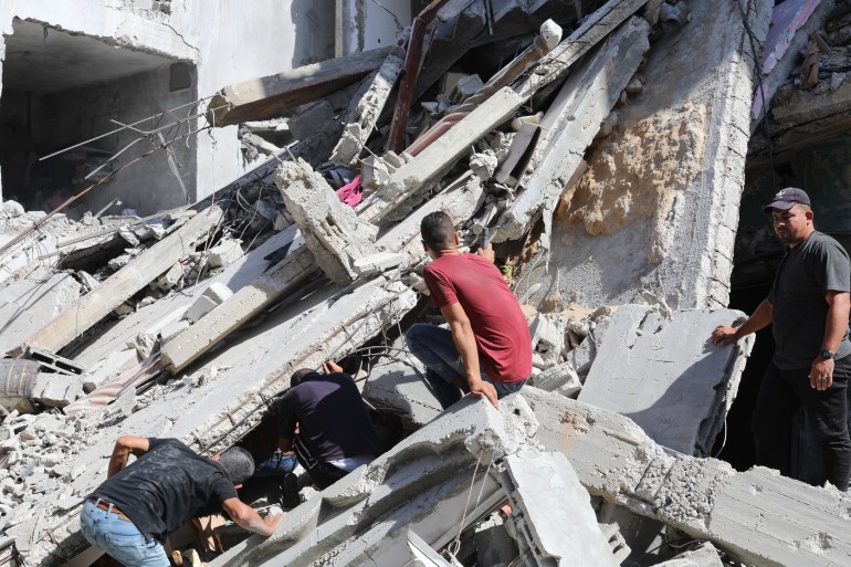 GAZA CITY, GAZA - 08 OKTOBER: Tim pertahanan sipil dan warga Palestina melakukan operasi pencarian dan penyelamatan di sekitar kehancuran menyusul serangan Israel di kamp pengungsi Bureij di Kota Gaza, Gaza pada 08 Oktober