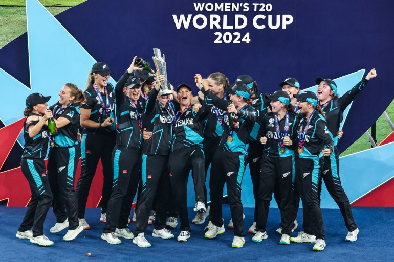 Para pemain Selandia Baru merayakan dengan trofi kemenangan mereka di penghujung pertandingan final kriket Piala Dunia T20 Wanita ICC antara Afrika Selatan dan Selandia Baru di Stadion Kriket Internasional Dubai di Dubai pada 20 Oktober 2024. (Foto oleh FADEL SENNA / AFP)