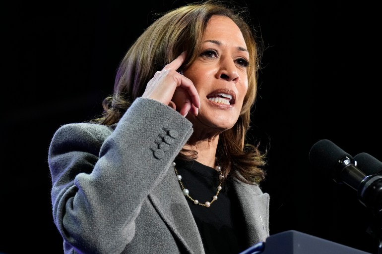 Kamala Harris berbicara, menunjuk ke kepalanya sebagai isyarat.