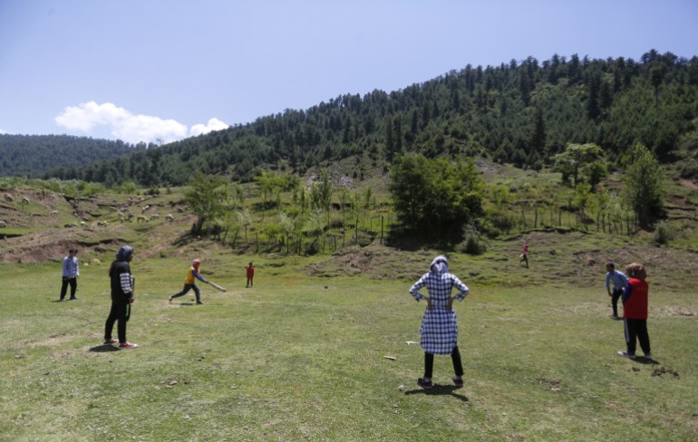 Anak laki-laki dan perempuan bermain kriket di sebuah desa indah di distrik Bandipora Kashmir utara di Kashmir yang dikelola India. (Shuaib Bashir/Al Jazeera)