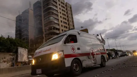 Getty Images Ambulans di sebuah apartemen yang terkena serangan udara Israel di Beirut. Pejabat kesehatan Lebanon mengatakan ambulans dan rumah sakit telah rusak akibat serangan udara langsung Israel.  