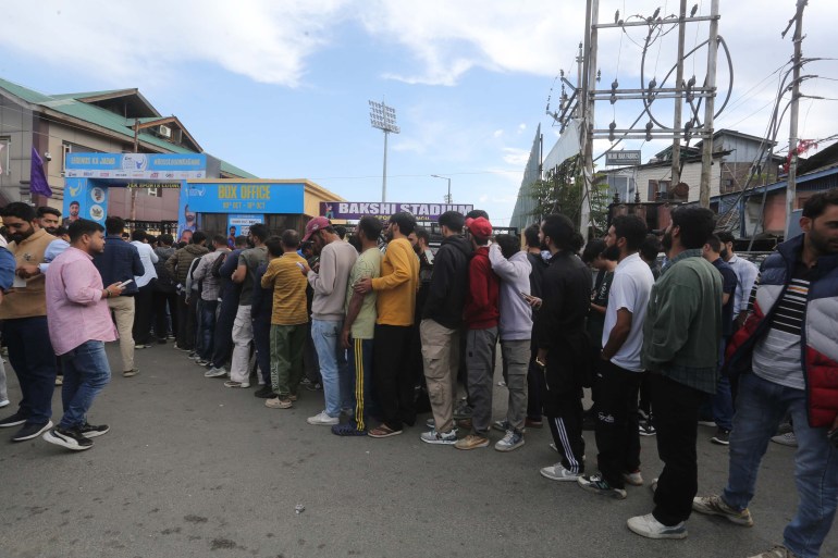 Orang-orang mengantri di luar loket tiket di Stadion Bakshi di kota utama Srinagar di Kashmir yang dikelola India di mana pertandingan Legends League Cricket diadakan. (Shuaib Bashir/Al Jazeera)