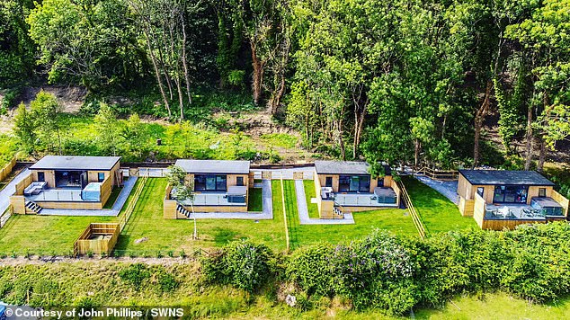 Phillips membangun pondok di tamannya di Gower, South Wales, pada tahun 2022 dan sejak itu menyewakannya dengan harga hingga £185 per malam. Dalam foto: pemandangan udara dari empat chalet