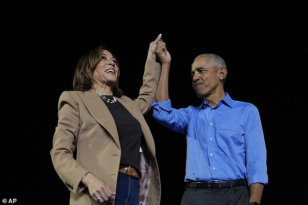 Barack Obama mengangkat tangan Harris saat kampanye di Stadion James R. Hallford di Clarkston, Georgia, pada 24 Oktober.