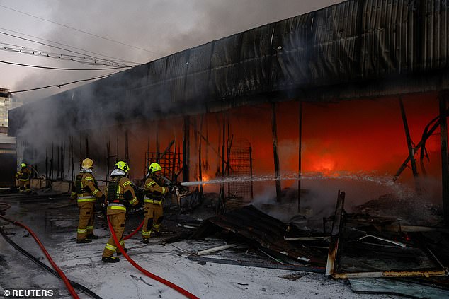 Petugas pemadam kebakaran bekerja di kompleks gudang sayuran yang terkena serangan pesawat tak berawak Rusia