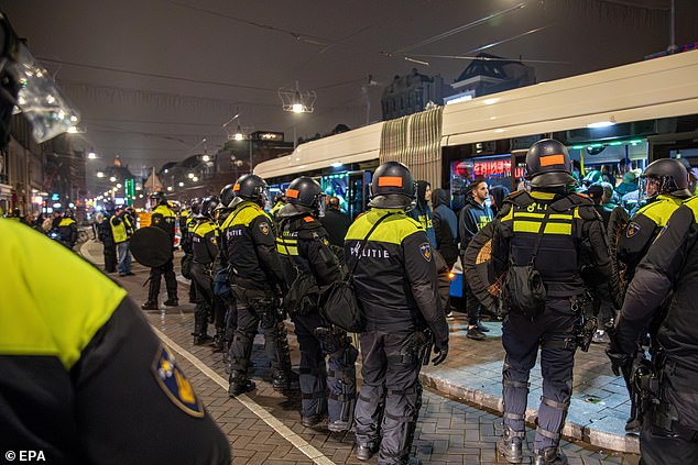 Polisi membuat garis keamanan di sekitar bus setelah pertandingan antara Ajax dan Maccabi Tel Aviv