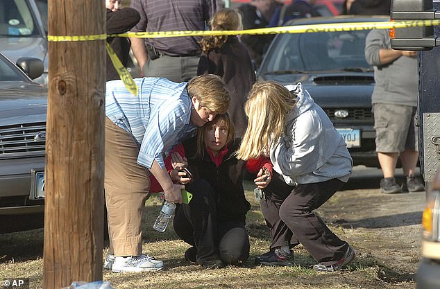 Orang-orang terhibur di dekat Sekolah Dasar Sandy Hook pada 14 Desember 2012 di Newtown