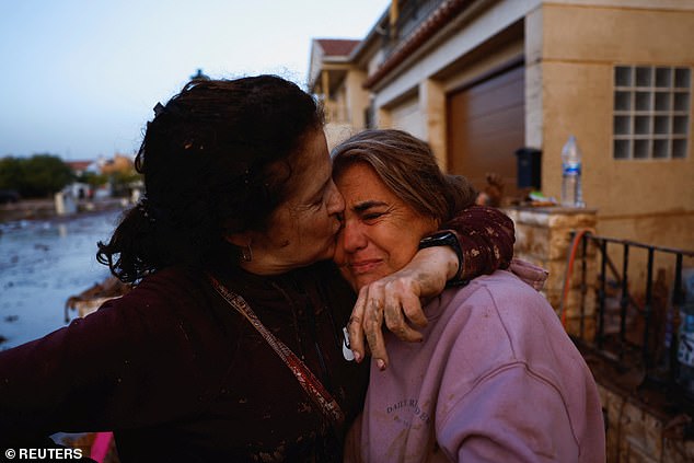 Seorang wanita menghibur temannya setelah banjir di Utiel, Spanyol. Pada Selasa malam, pihak berwenang mengatakan lebih dari 36.000 orang telah diselamatkan di seluruh wilayah Valencia sejak banjir pekan lalu.