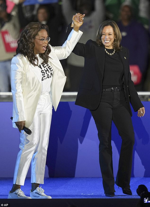 Oprah Winfrey berpegangan tangan dengan calon wakil presiden dari Partai Demokrat Kamala Harris setelah memperkenalkannya untuk berbicara dalam rapat umum kampanye di depan Museum Philadelphia Senin malam lalu